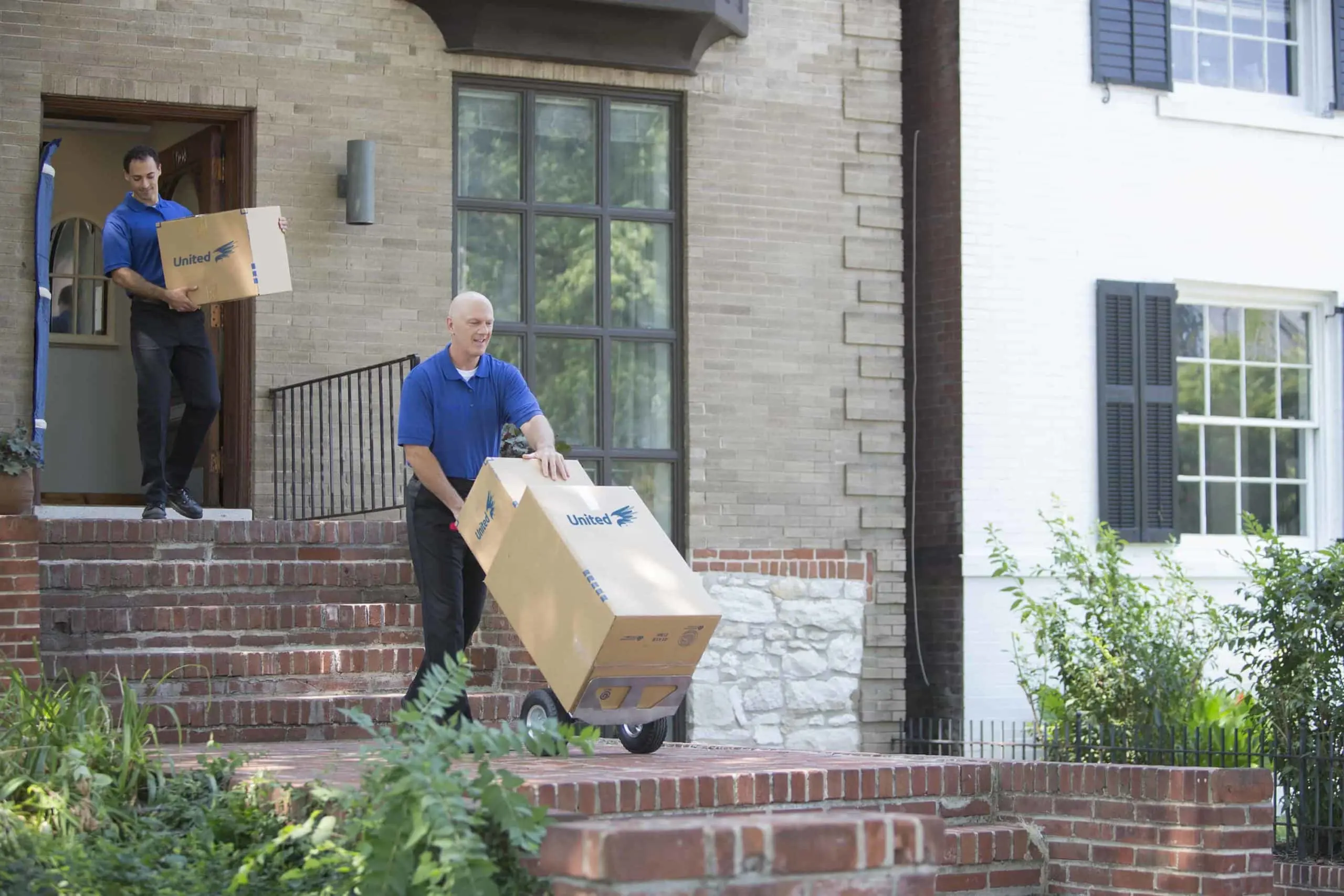 two movers transporting boxes from a home -- United Van Lines®