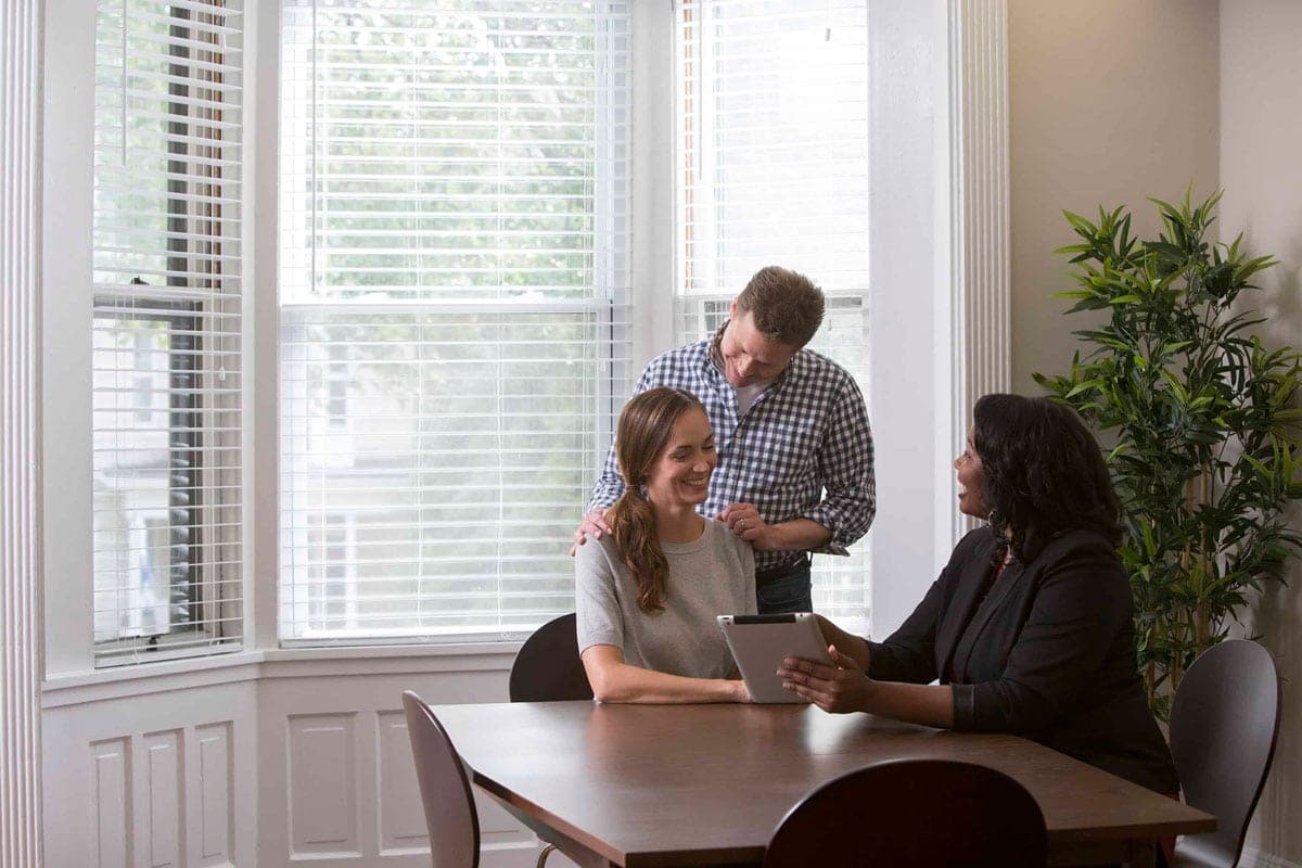 united van lines agent goes over moving options with an excited couple at their kitchen table.