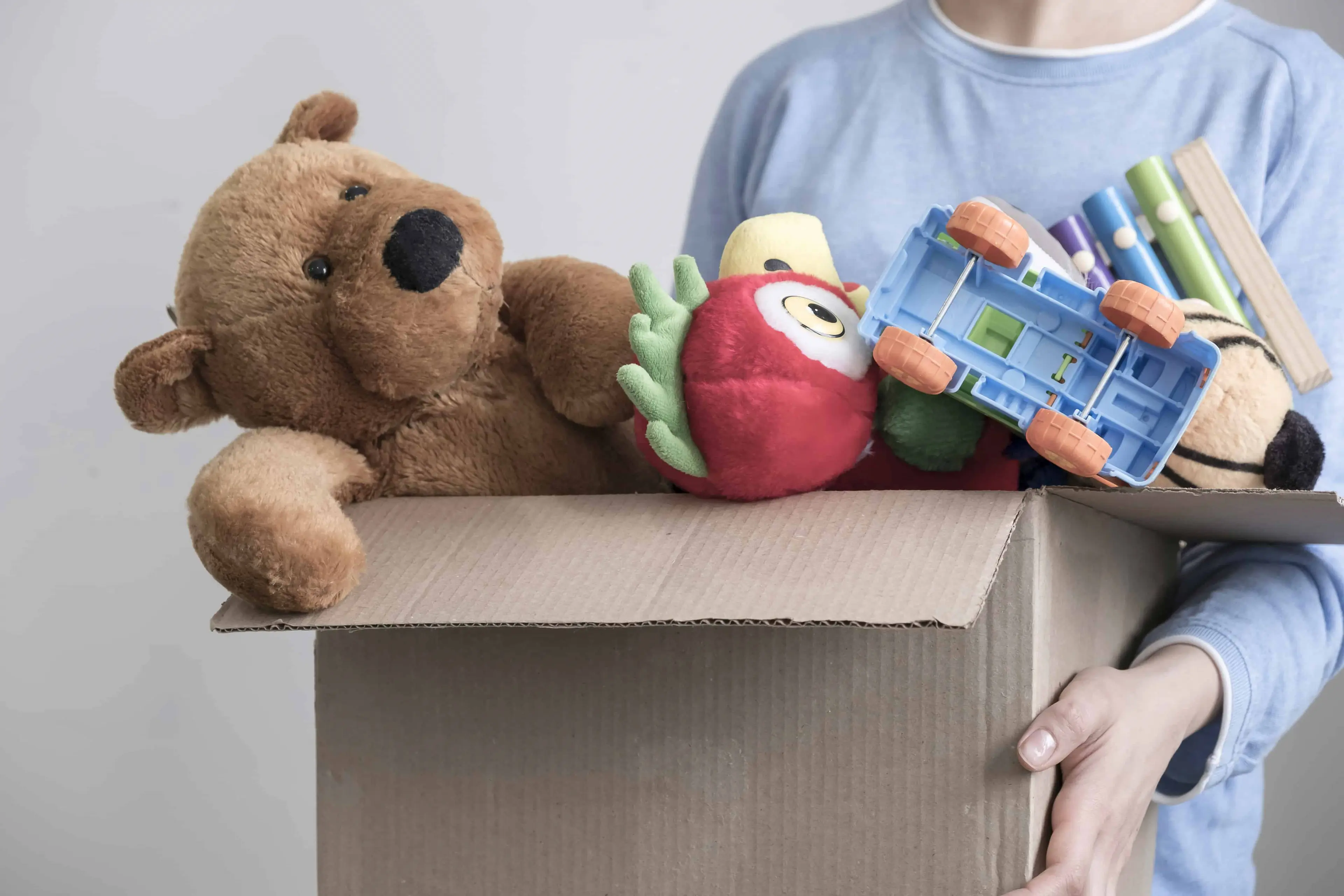 How to Cut Moving Costs - Male volunteer holding donation box with old toys - United Van Lines