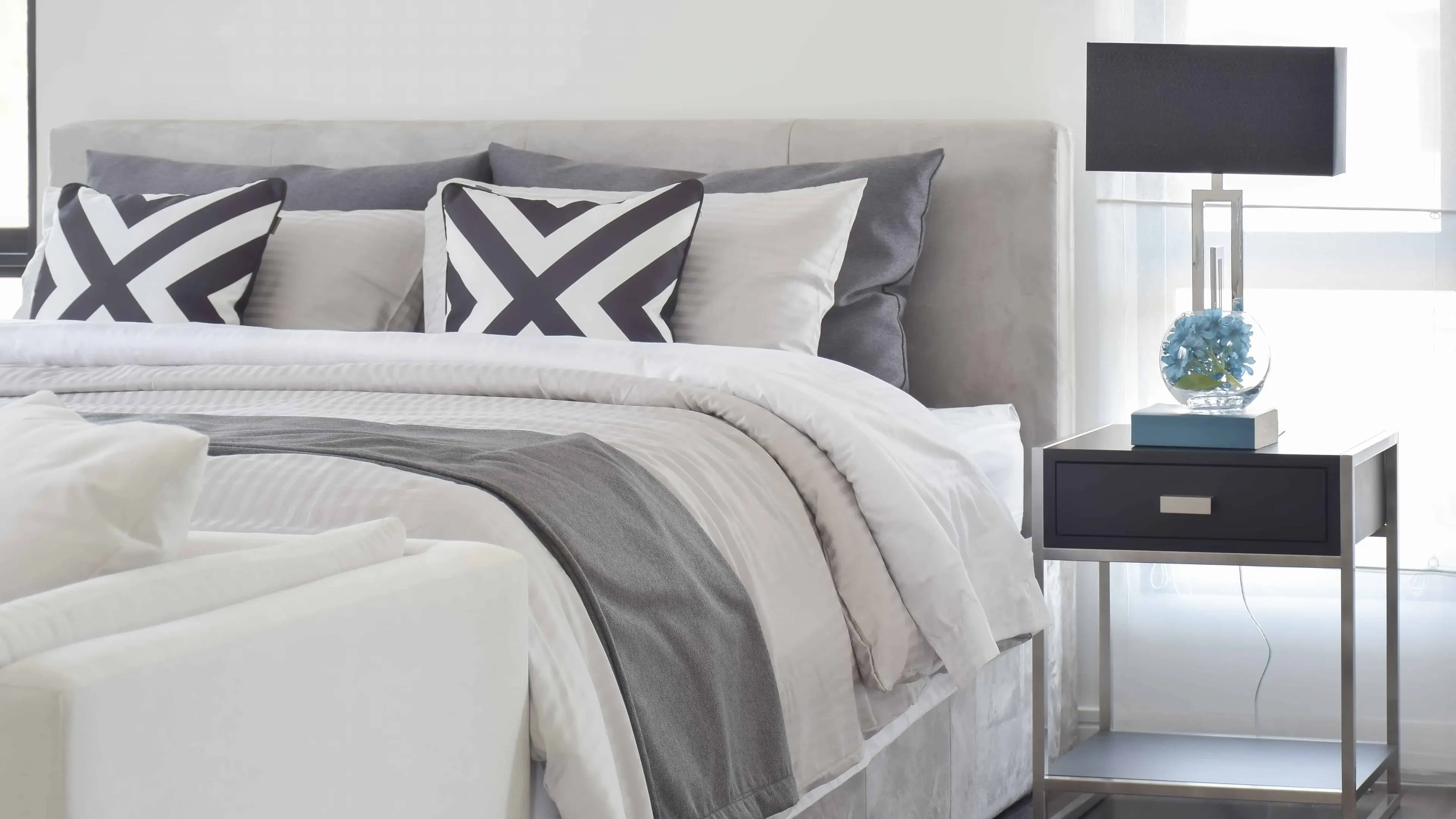 How To Pack Bedding & More - Modern Gray tone bedding and bedside table and lamp in black - United Van Lines